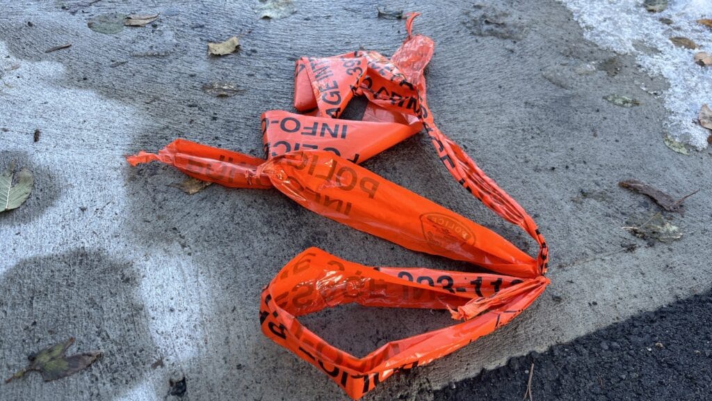 Five Suspects Arrested After Overnight Break-In at Town of Mount Royal Home, Montreal Police Say 1 Crumpled orange police line tape on icy sidewalk after Montreal SPVM break-in investigation in Town of Mount Royal