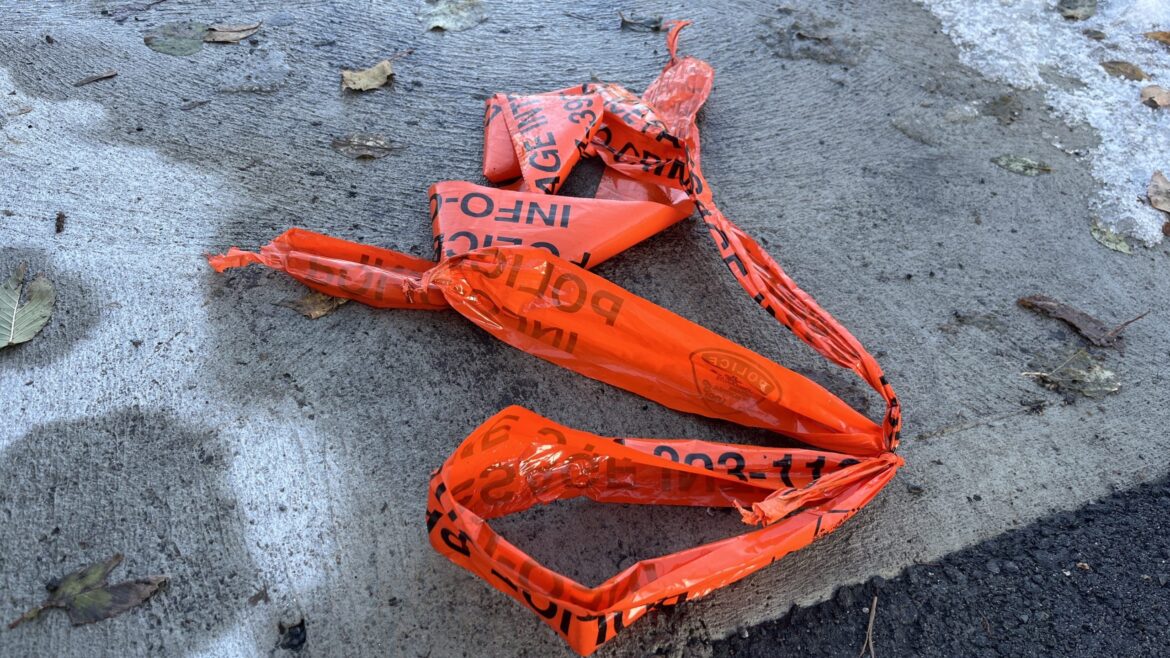 Crumpled orange police line tape on icy sidewalk after Montreal SPVM break-in investigation in Town of Mount Royal